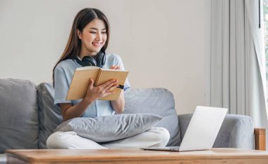 Asyalı kız öğrenci çevrimiçi öğrenme dersi alıyor. Çevrimiçi video öğretmeni, Mutlu Asyalı kız evde bilgisayar laptopuyla İngilizce öğreniyor.