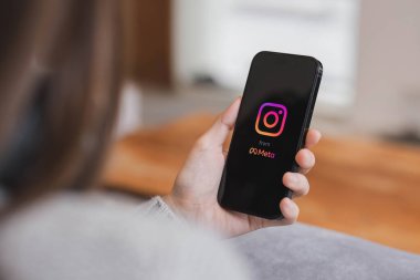 CHIANG MAI, THAILAND - 17 APR 2023: Kafedeki ekranda Apple iPhone 14 uygulaması olan bir kadın var. Instagram akıllı telefonlar için fotoğraf paylaşım uygulamasıdır...