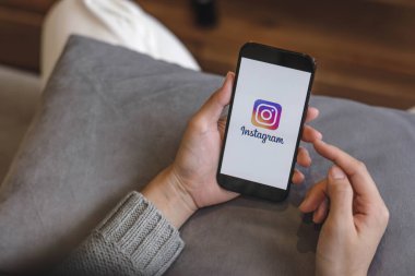CHIANG MAI, THAILAND - 17 APR 2023: Kafedeki ekranda Apple iPhone 14 uygulaması olan bir kadın var. Instagram akıllı telefonlar için fotoğraf paylaşım uygulamasıdır...
