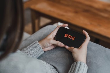 CHIANG MAI, THAILAND, APR 17, 2022: Apple iPhone 14 üzerinde Netflix logosu olan akıllı telefonu tutan kadın. Netflix, dünya çapında bir dizi ve film sağlayıcısıdır....