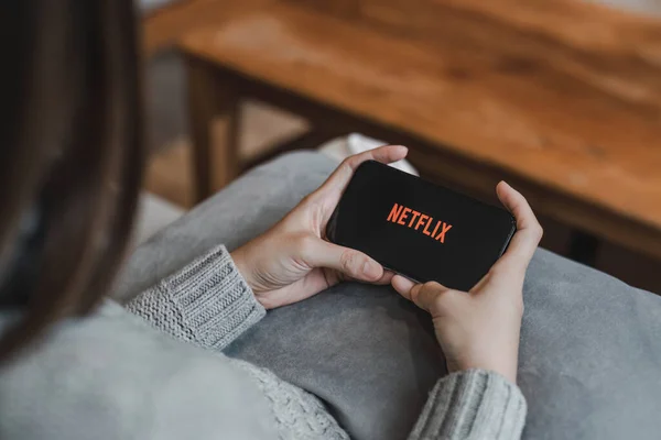 stock image CHIANG MAI, THAILAND, APR 17, 2022: Woman hand holding Smart Phone with Netflix logo on Apple iPhone 14. Netflix is a global provider of streaming movies and TV series...