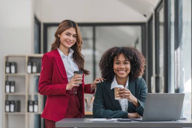 İki iş adamı toplantı odasında proje stratejisi hakkında konuşuyor. İş adamı, mali veri raporu hakkında sohbet ve tavsiyelerde bulunurken, modern işyerindeki iş arkadaşıyla proje planlamasını tartıştı
