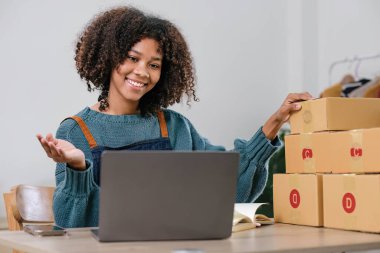 Küçük işletme girişimcisi KME ya da kutulu laptop kullanan serbest çalışan Asyalı kadın, elini kaldıran genç başarılı Asyalı kadın, çevrimiçi pazarlama kutusu ve teslimatı, KME kavramı..