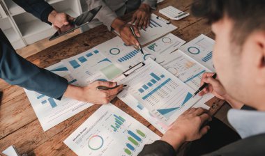 Business People Meeting using laptop computer,calculator,notebook,stock market chart paper for analysis Plans to improve quality next month. Conference Discussion Corporate Concept