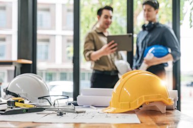 İnşaat mühendisi takımları modern kentteki inşaat sahasında birlikte çalışan işçi kaskı takıyorlar. Foreman Endüstri Mühendislik Mühendisliği ekip çalışması. Asya endüstrisi profesyonel takımı...