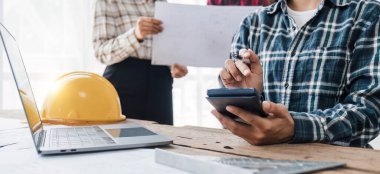 İnşaat mühendisi takımları modern kentteki inşaat sahasında birlikte çalışan işçi kaskı takıyorlar. Foreman Endüstri Mühendislik Mühendisliği ekip çalışması. Asya endüstrisi profesyonel takımı.