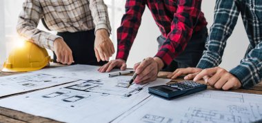 İnşaat mühendisi takımları modern kentteki inşaat sahasında birlikte çalışan işçi kaskı takıyorlar. Foreman Endüstri Mühendislik Mühendisliği ekip çalışması. Asya endüstrisi profesyonel takımı.