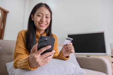 Ecommerce, hands or woman with credit card or phone for a digital payment on sofa relaxing at home. Smile, finance or happy girl online shopping for subscription sales offer, banking or fintech deal..