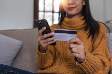 Evdeki kanepede dinlenen dijital bir ödeme için kredi kartı ya da telefonu olan kadın ya da ticaret. Gülümse, finans ya da mutlu kız çevrimiçi abonelik satış teklifi, bankacılık ya da fintech anlaşması için alışveriş yapıyor...