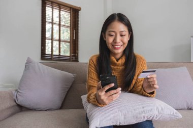 Ecommerce, hands or woman with credit card or phone for a digital payment on sofa relaxing at home. Smile, finance or happy girl online shopping for subscription sales offer, banking or fintech deal..