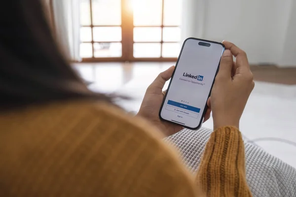 CHIANGMAI, THAILAND - 1 Mayıs 2023: Bir kadın ekranda LinkedIn uygulaması ile Apple iPhone 14 tutuyor. LinkedIn akıllı telefonlar için fotoğraf paylaşım uygulaması...
