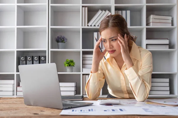 스트레스를 아시아 여성은 자신의 책상에 보고서를 재검토하는 집중하고 — 스톡 사진