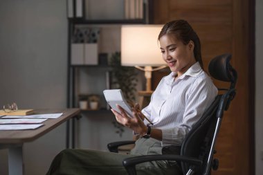 İş kadını, ofis ve iş geçmişinde, vergi, muhasebe, istatistik ve analitik araştırma kavramında matematik finansmanı için hesap makinesi kullanıyor....