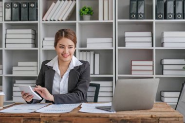 İş kadını, ofis ve iş geçmişinde, vergi, muhasebe, istatistik ve analitik araştırma kavramında matematik finansmanı için hesap makinesi kullanıyor.....