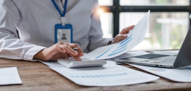 İş kadını, ofis ve iş geçmişinde, vergi, muhasebe, istatistik ve analitik araştırma kavramında matematik finansmanı için hesap makinesi kullanıyor..