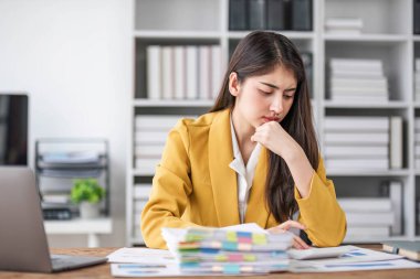 Asyalı iş kadını iş yerinde problem çözmeyi düşünüyor. Endişeli Asyalı genç bir kadın endişeli. Düşüncelerinde zor kararlar veriyorlar....