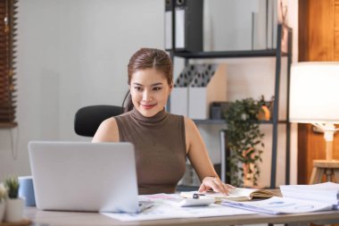 İş kadını, ofis ve iş geçmişinde, vergi, muhasebe, istatistik ve analitik araştırma kavramında matematik finansmanı için hesap makinesi kullanıyor.