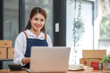 İş yerinde bir kutuyla çalışan Asyalı genç kadın KOBİ 