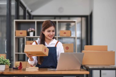 Başlangıçta mutlu Asyalı kadın işyeri sahibi ev ofisinde gişe hasılatıyla çalışıyordu. Paket teslimat KOBİ tedarik zinciri, satın alma ve paket kutusunu müşterilere, Çevrimiçi KOBİ iş girişimcilerine teslim etmek üzere hazırlayın