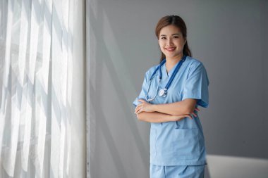 Klinikteki ofisinde duran Asyalı kadın doktorun portresi....