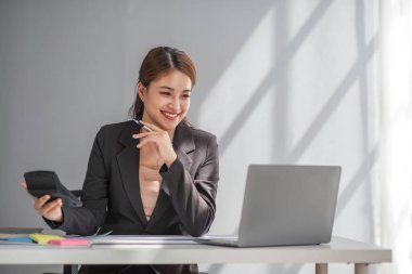 İş kadını, ofis ve iş geçmişinde, vergi, muhasebe, istatistik ve analitik araştırma kavramında matematik finansmanı için hesap makinesi kullanıyor.