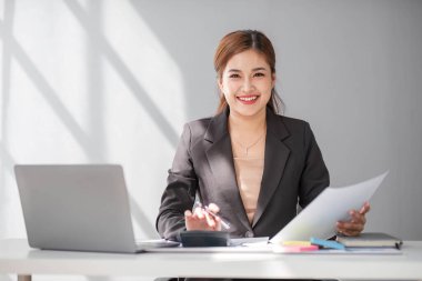 İş kadını, ofis ve iş geçmişinde, vergi, muhasebe, istatistik ve analitik araştırma kavramında matematik finansmanı için hesap makinesi kullanıyor.