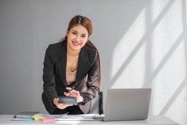 İş kadını, ofis ve iş geçmişinde, vergi, muhasebe, istatistik ve analitik araştırma kavramında matematik finansmanı için hesap makinesi kullanıyor.