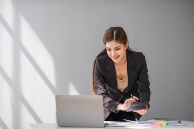 İş kadını, ofis ve iş geçmişinde, vergi, muhasebe, istatistik ve analitik araştırma kavramında matematik finansmanı için hesap makinesi kullanıyor.