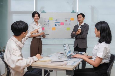 Bir grup yaratıcı Asya iş toplantısı ve strateji başlangıç projesi analizi finansmanı. Asyalı iş adamları planlarını ve beyin fırtınası pazarlama fikrini ofiste dizüstü bilgisayarla çalışıyorlar. Takım çalışması