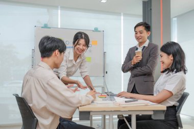 Bir grup yaratıcı Asya iş toplantısı ve strateji başlangıç projesi analizi finansmanı. Asyalı iş adamları planlarını ve beyin fırtınası pazarlama fikrini ofiste dizüstü bilgisayarla çalışıyorlar. Takım çalışması