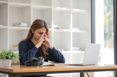 Asyalı kadınlar çevrimiçi çalışmalarından sıkılırlar, üzgün bir yüzleri vardır ve uzun zamandır çalışmaktan yorulmuşlardır....