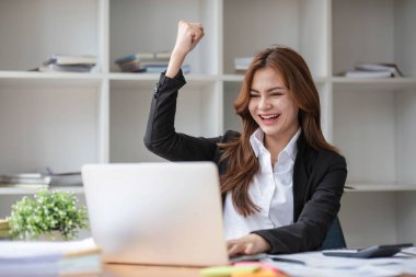 Heyecanlı bir bayanın sevinçle kutlaması çevrimiçi galibiyet başarısı sonucu, iyi e-posta haberlerinden mutlu genç bir kadın, büyük bir teklifle ya da yeni bir fırsatla motive olmuş, sınavı geçmiş, bir iş bulmuş...