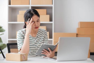 Küçük işletmeler, Girişim KOBİ, Girişimciler. İnternetten alışveriş yapan Asyalı bir kadın ağlıyor ve mutsuz bir yüz ifadesi takınıyor....