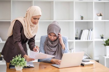 Profesyonel Müslüman iş adamları, ofis odasında önemli bir proje üzerinde tartışıyorlar....
