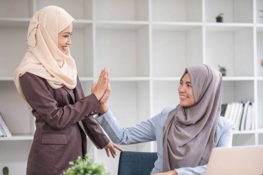 Müslüman iş adamlarından oluşan mutlu ve başarılı bir ekip etkileyici sonuçtan sonra kutlama yapıyor....