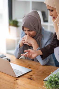 Profesyonel Müslüman iş adamları, ofis odasında önemli bir proje üzerinde tartışıyorlar....