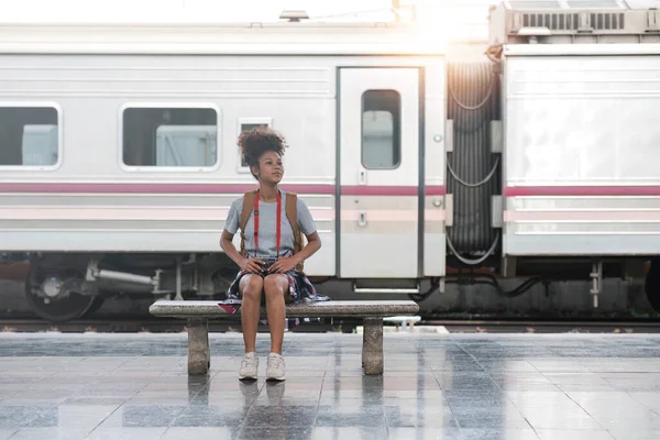 stock image Young Asian African woman traveler with backpack in the railway train station, traveler girl walking stand sit waiting take a picture on railway platform train station. High quality photo..