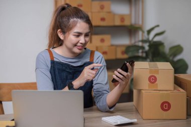Başlangıçta küçük işletme girişimcisi KME, Asyalı kadın telefonla sipariş alıyor. Portre genç Asyalı küçük işletme sahibi ev sahibi, çevrimiçi pazarlama teslimatı KOBİ-ticaret tele pazarlama kavramı