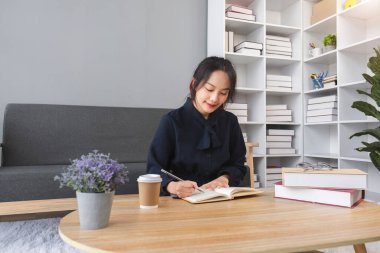 Asyalı genç bayanı kapatın. Defter günlüğüne anılarınızı yazın. Ödevlerinizi yapın..