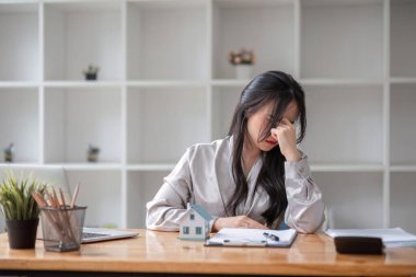 Ofiste çalışırken stresli görünen bir iş kadını. Dizüstü bilgisayardan çalışan stresli iş kadını endişeli, yorgun ve bunalmış görünüyor..