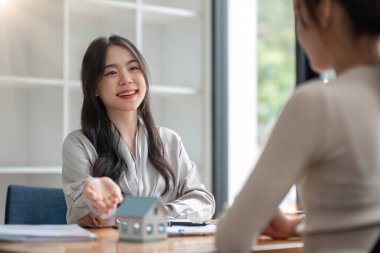 Emlakçı ev satın alma anlaşmasının şartlarını tartıştı ve müşteriden sözleşmeyi yasal hale getirmek için belgeleri imzalamasını istedi, ev satışları, kira kontratı, ipotek ve ev sigortası...