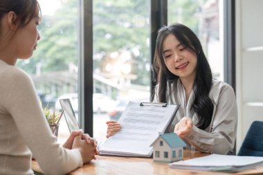 Emlakçı ev satın alma anlaşmasının şartlarını tartıştı ve müşteriden sözleşmeyi yasal hale getirmek için belgeleri imzalamasını istedi, ev satışları, kira kontratı, ipotek ve ev sigortası...