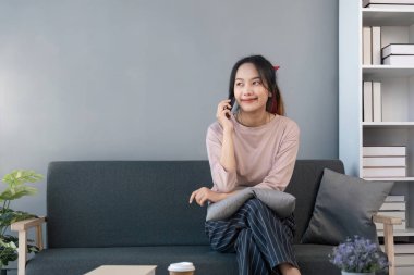 Mutlu, güzel, Asyalı bir kadın. Güzel haberler dinliyor. Hoş bir telefon görüşmesi yapıyor, bilgisayar işinden uzaklaşıyor arkadaşlarıyla konuşuyor, uzaktan iletişim kuruyor..