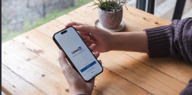 CHIANG MAI, THAILAND, JUL 7, 2023: Bir kadın ekranında LinkedIn uygulaması olan Apple iPhone 14 'ü tutuyor. LinkedIn akıllı telefonlar için fotoğraf paylaşım uygulaması..