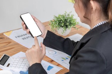 Ofiste otururken ekranda beyaz ekranı gösteren telefonu tutan kadın..