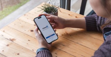 CHIANG MAI, THAILAND, JUL 7, 2023: Bir kadın ekranında LinkedIn uygulaması olan Apple iPhone 14 'ü tutuyor. LinkedIn akıllı telefonlar için fotoğraf paylaşım uygulaması..