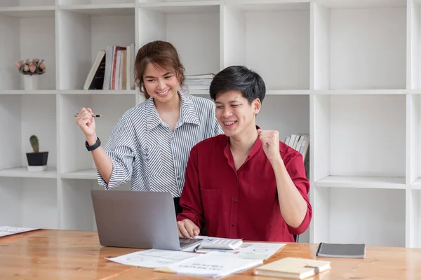 İki neşeli Asyalı iş adamı, son zamanlarda bitirdikleri işleri mutlu yüzleriyle dizüstü bilgisayarlarında izliyorlar...