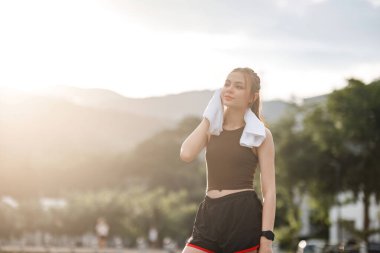 Güzel Asyalı kadın portresi parkta bir akşam koşusundan sonra terini sil...