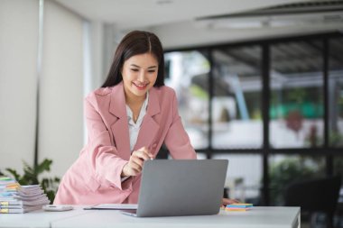 İş kadınları çalışma masasının yanında dikilirken dizüstü bilgisayara bakıyorlar...