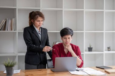 İki işadamı bilgisayardaki iş akışını meslektaşlarına anlatırken,..